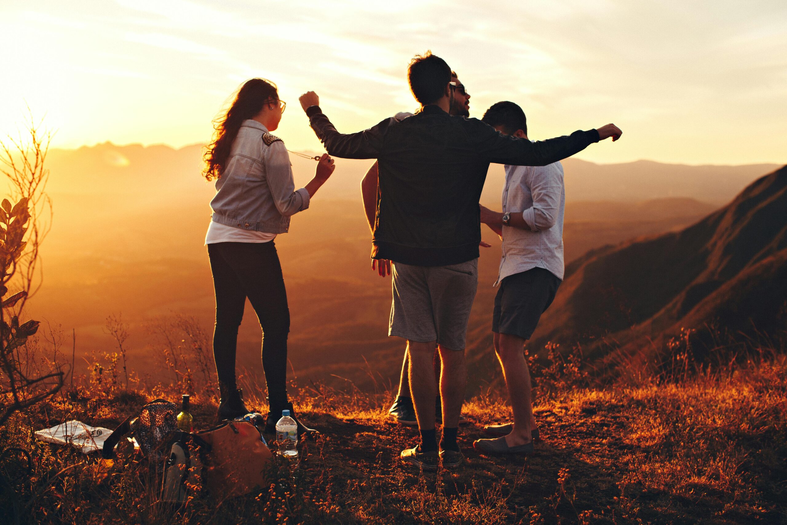 Silhouettes of people reaching toward a bright sunrise after a lonely passage