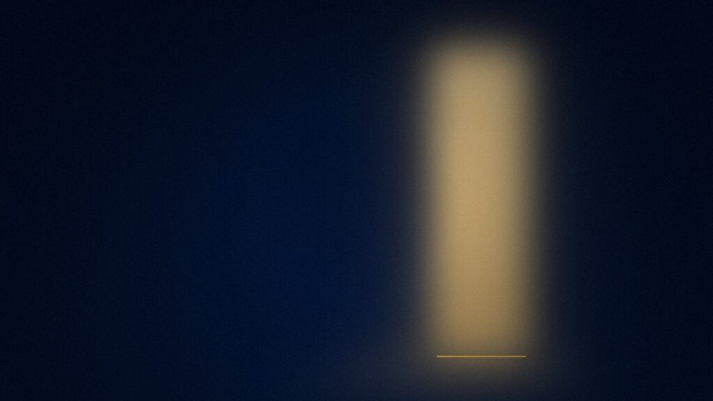 A doorway left open in a dark navy room with warm light spilling across the floor